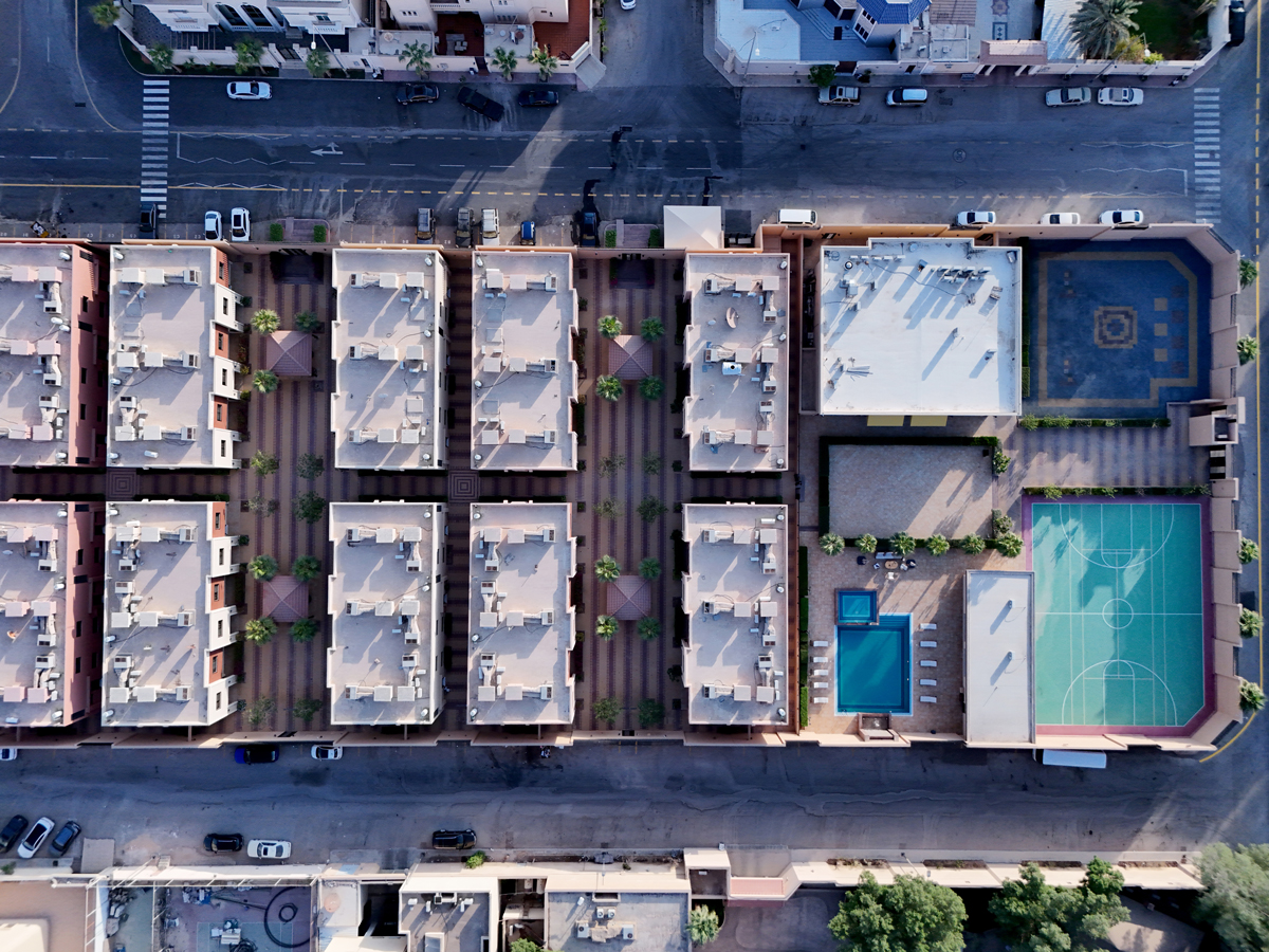 Aerial view of Creative Hospitality Compound in Saudi Arabia with residential villas, pool, and sports courts