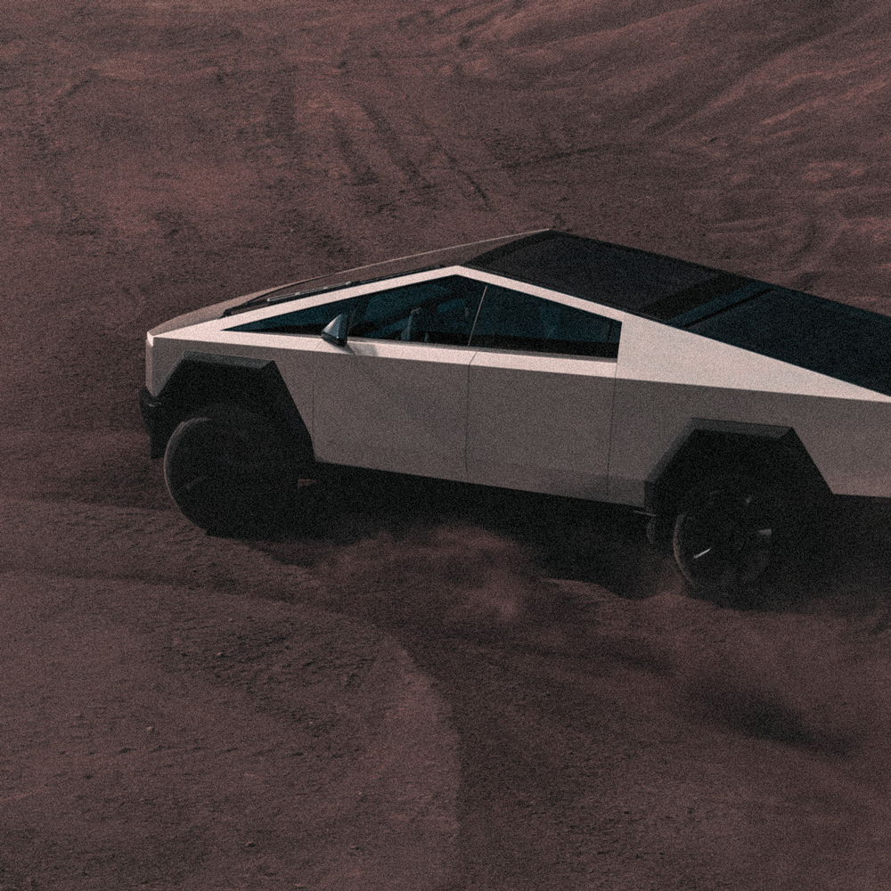 Futuristic Tesla Cybertruck driving on desert terrain, symbolizing Creative Hospitality’s bold and innovative approach to branding and design solutions.
